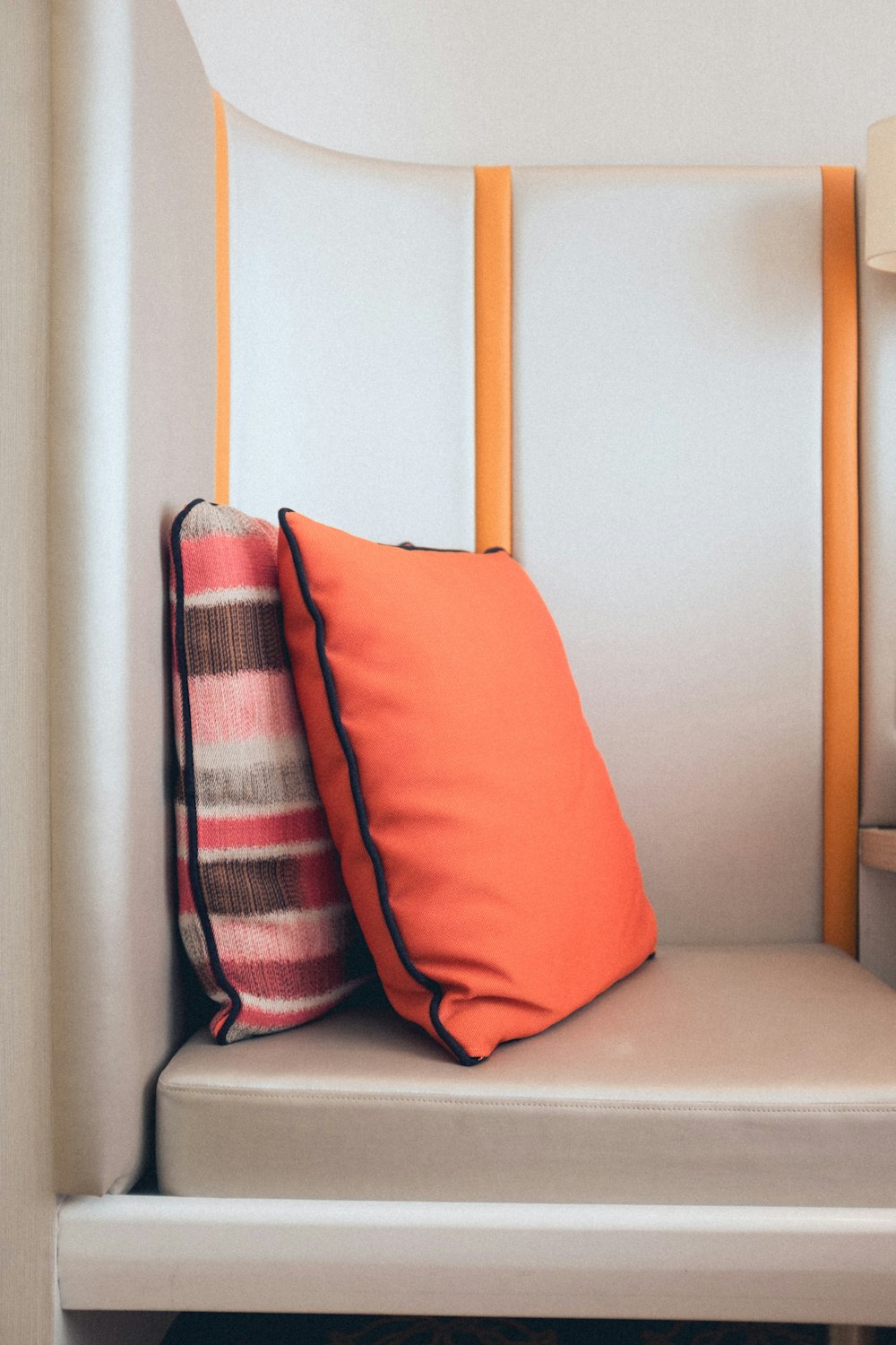 two standing orange throw pillows on sofa