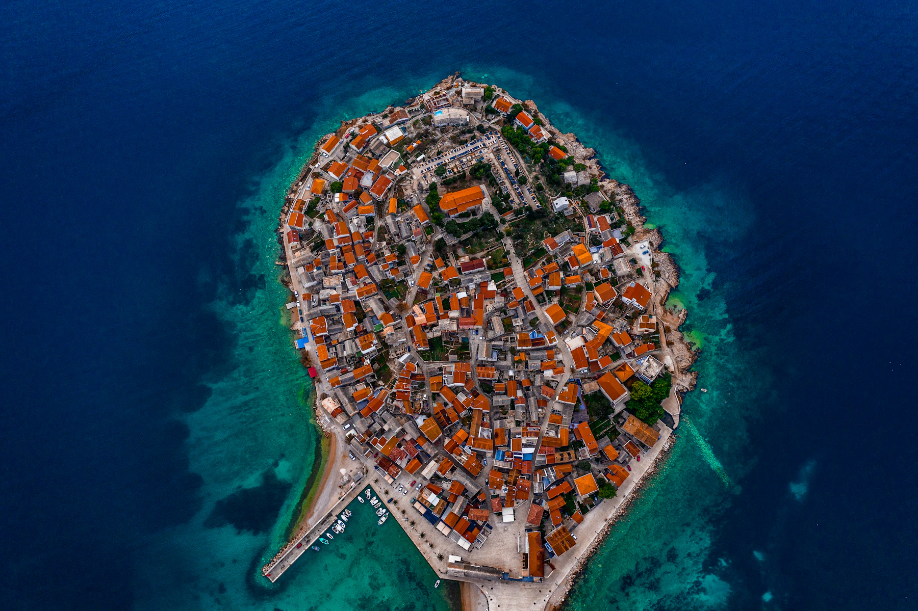 Buildings meet blue water along the Croatian coast.