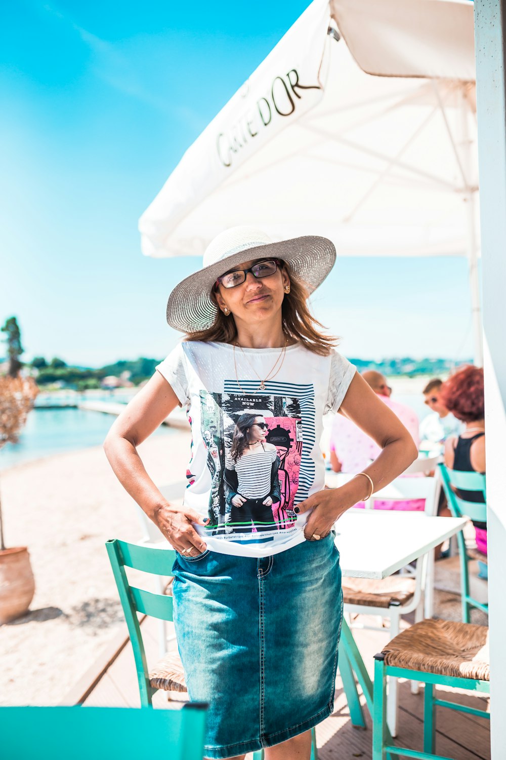 woman standing near parasol and chairs on beach