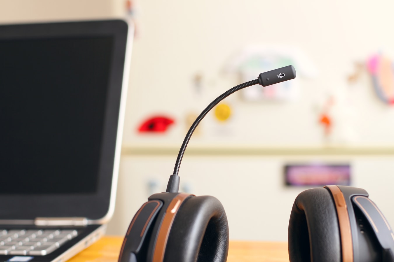 Headphones with microphone at desk with laptop