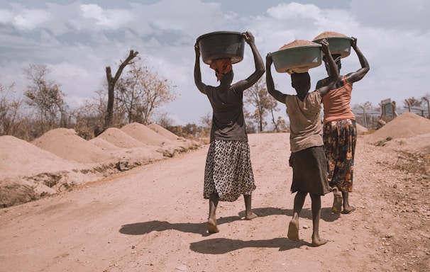 three women carrying basin while walking barefoot