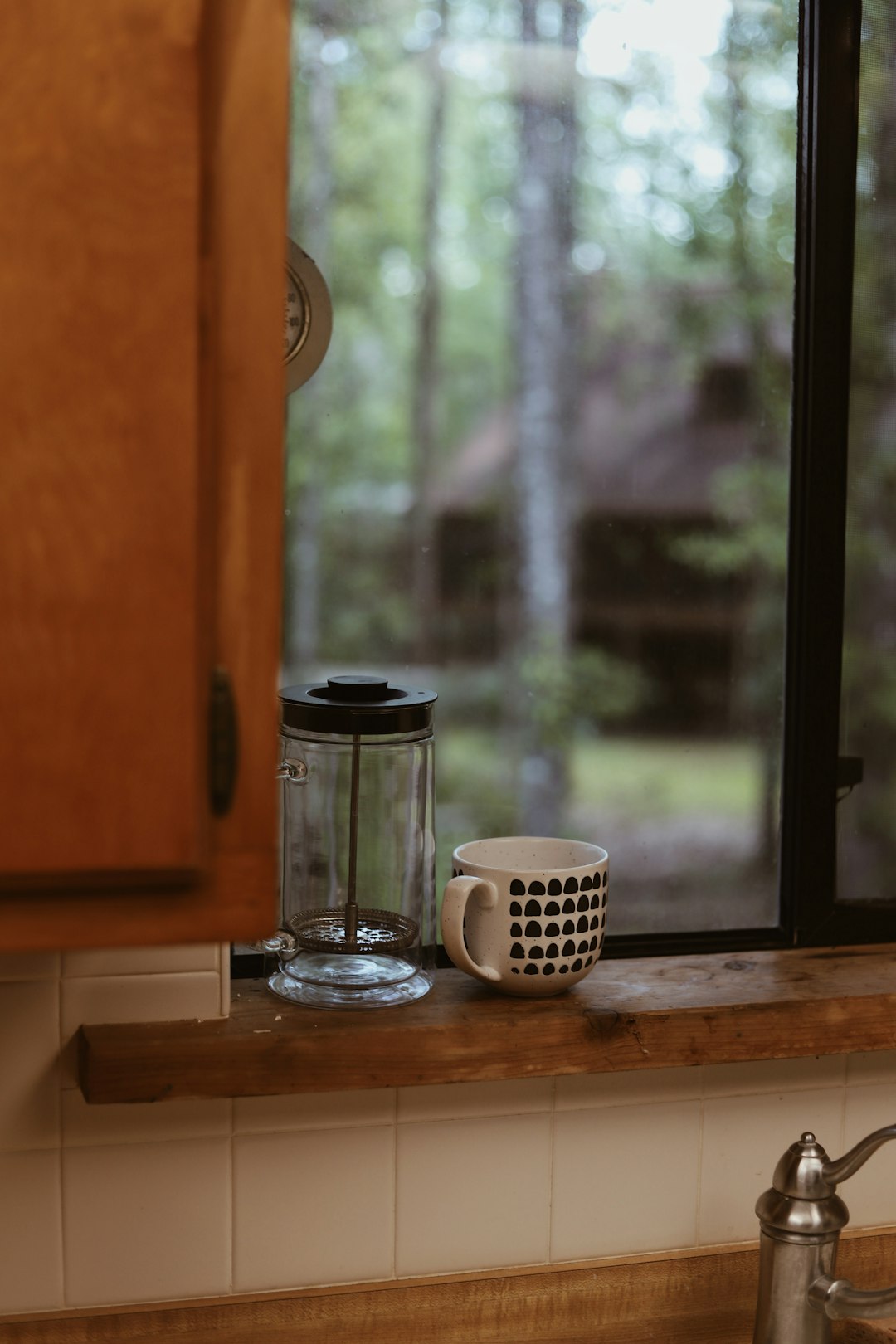 clear glass coffee pot on window sill