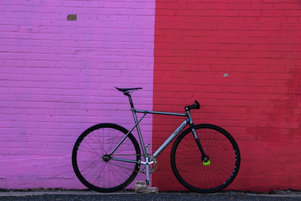 gray rigid bike leaning on wall during daytime