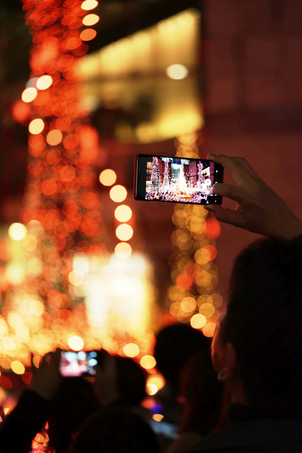 a person taking a picture of a christmas tree