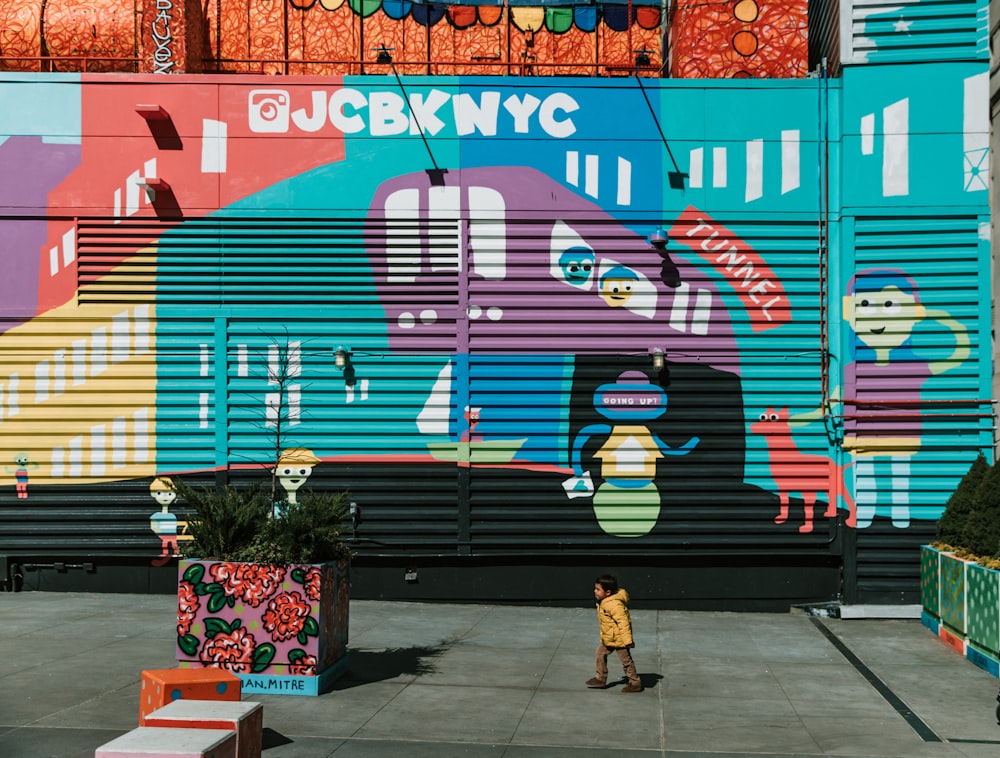 kid walking near wall with graffitis