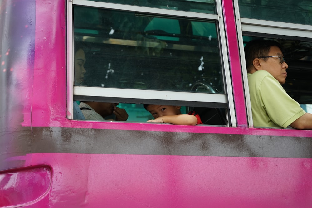 man sitting beside bus window