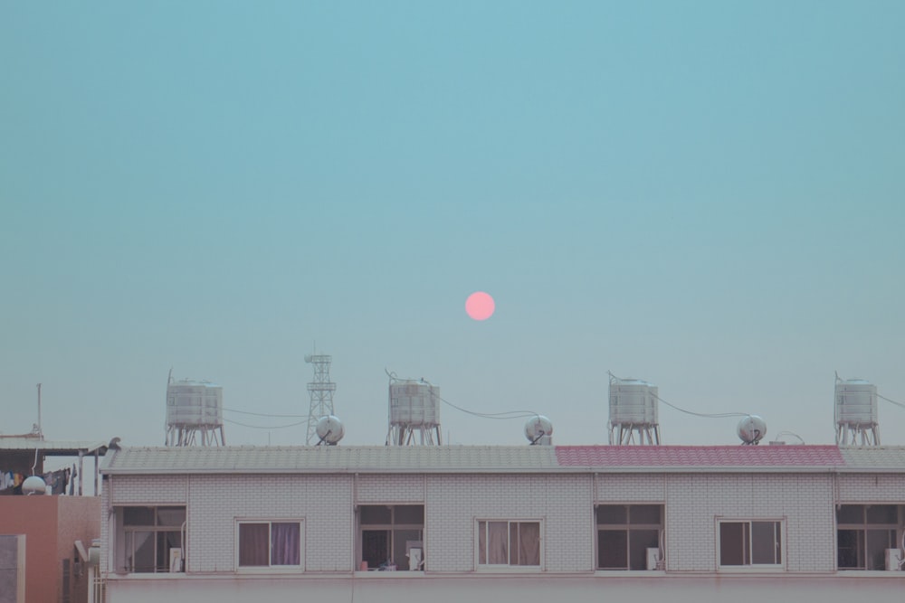 the sun is setting over the roof of a building