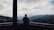 Man standing on a balcony overlooking the misty peaks of Soudah Mountain.
