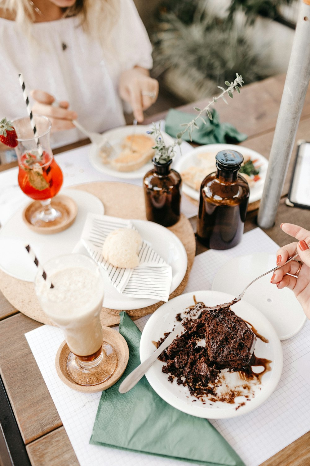 a woman sitting at a table with a plate of cake