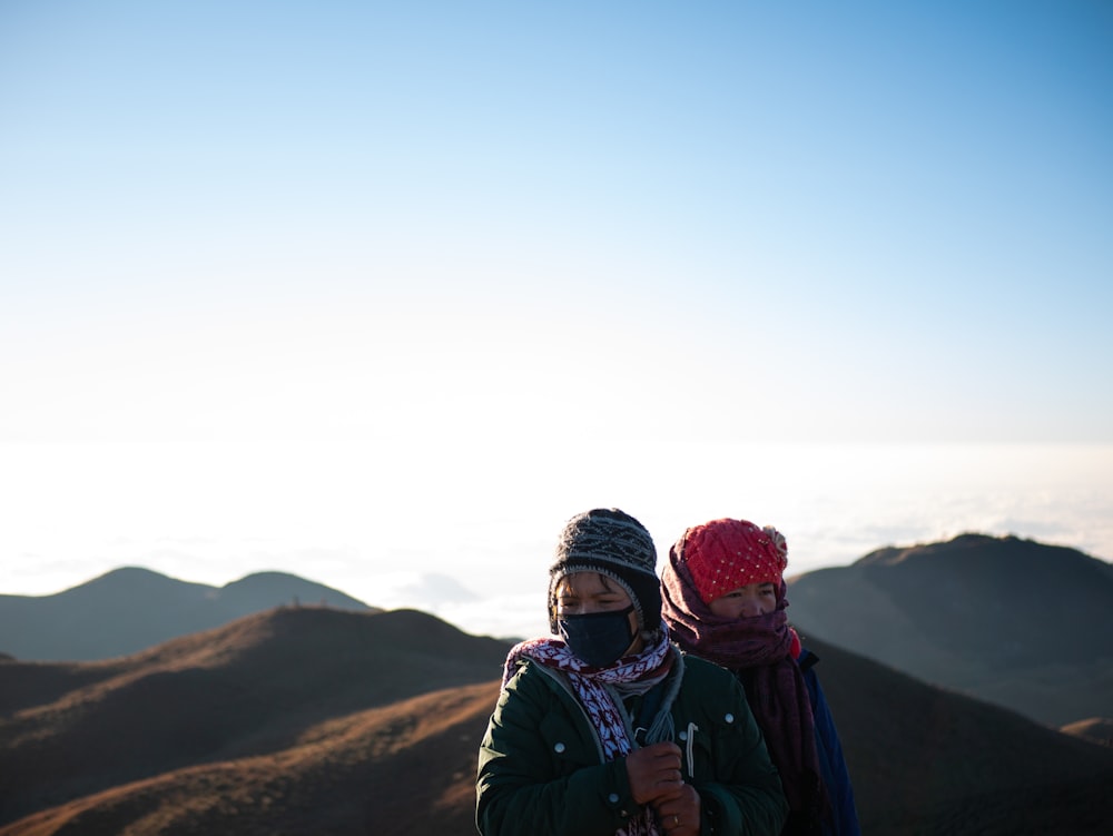 a couple of people standing on top of a mountain