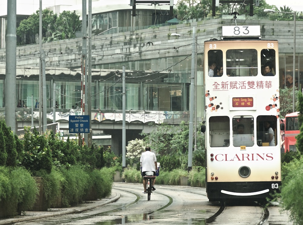 person riding bike beside bus during daytime