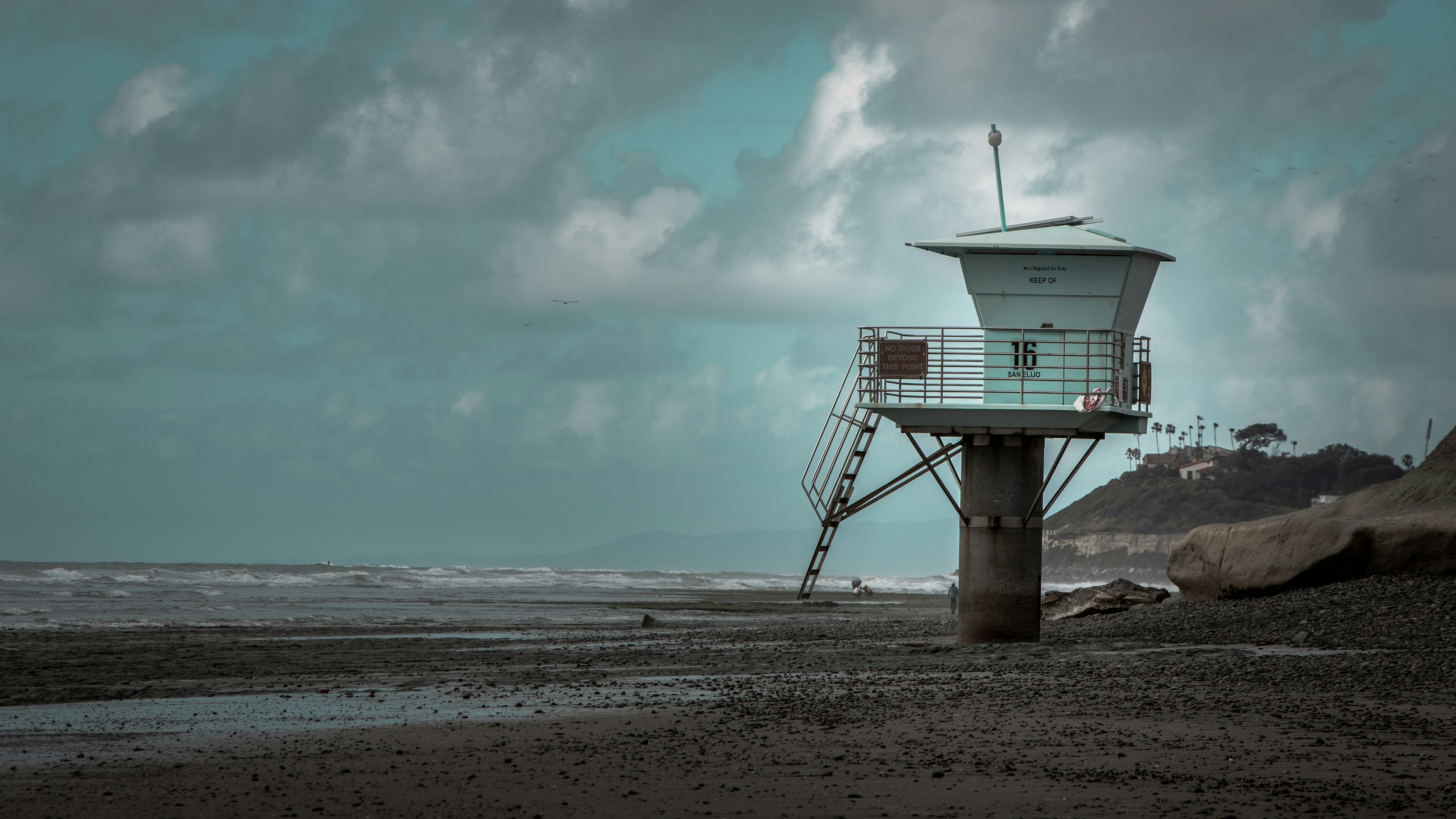 white and gray concrete lifeguard house under cloudy sky during daytime