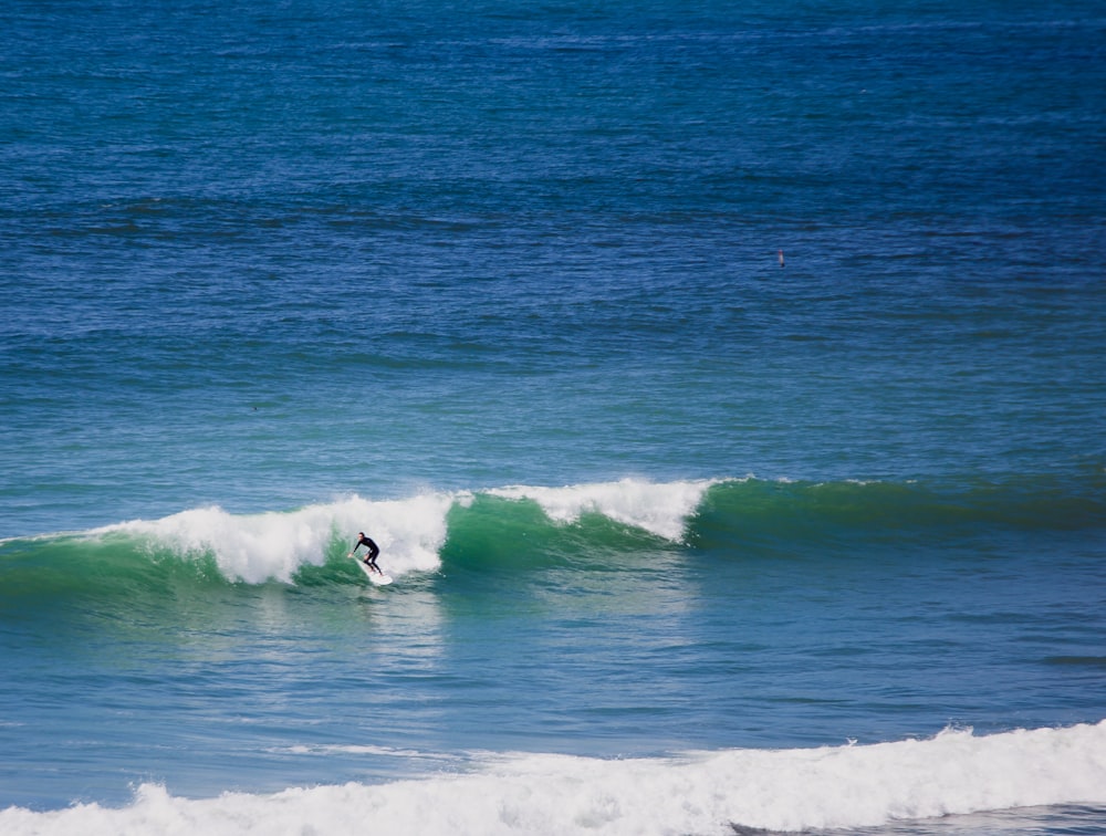 man doing stunt on surfboard during daytime