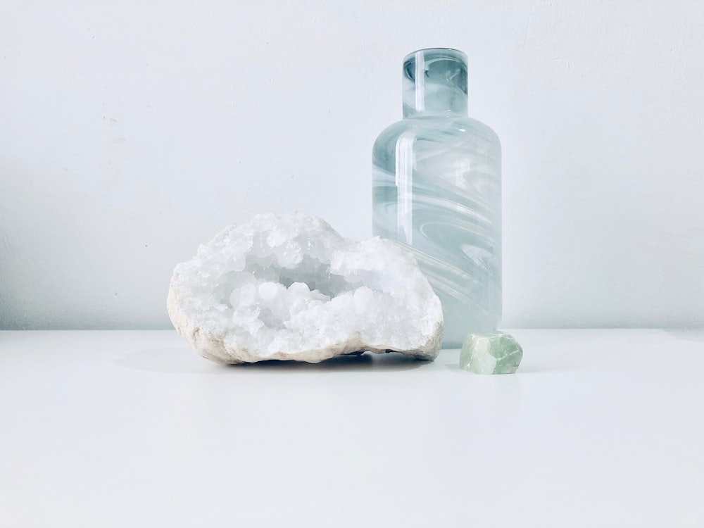 white geode beside clear bottle