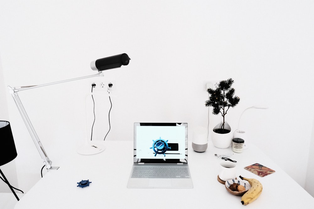 un ordinateur portable posé sur un bureau blanc