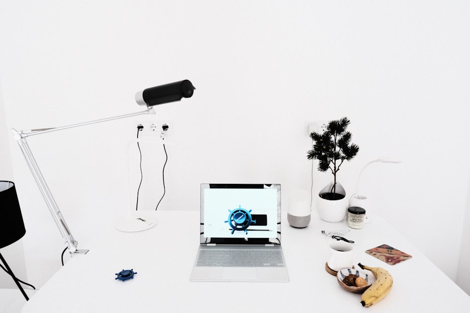 A laptop computer on a white desk in a calm, minimalist workspace, representing a dashboard review session.