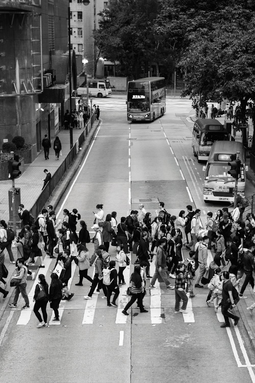 grayscale photography of people crossing road