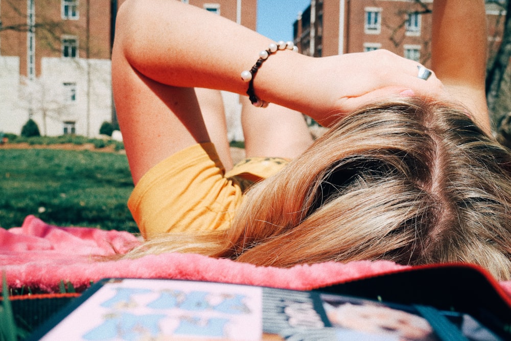 person lying near grass field during daytime