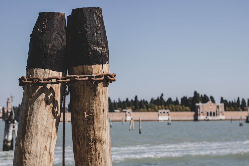 a pair of wooden poles with chains on them