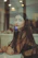 selective focus photography of woman standing beside window wall