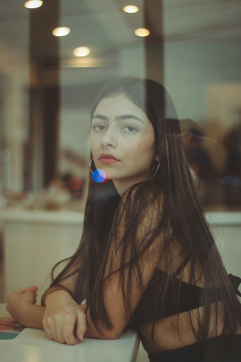 selective focus photography of woman standing beside window wall