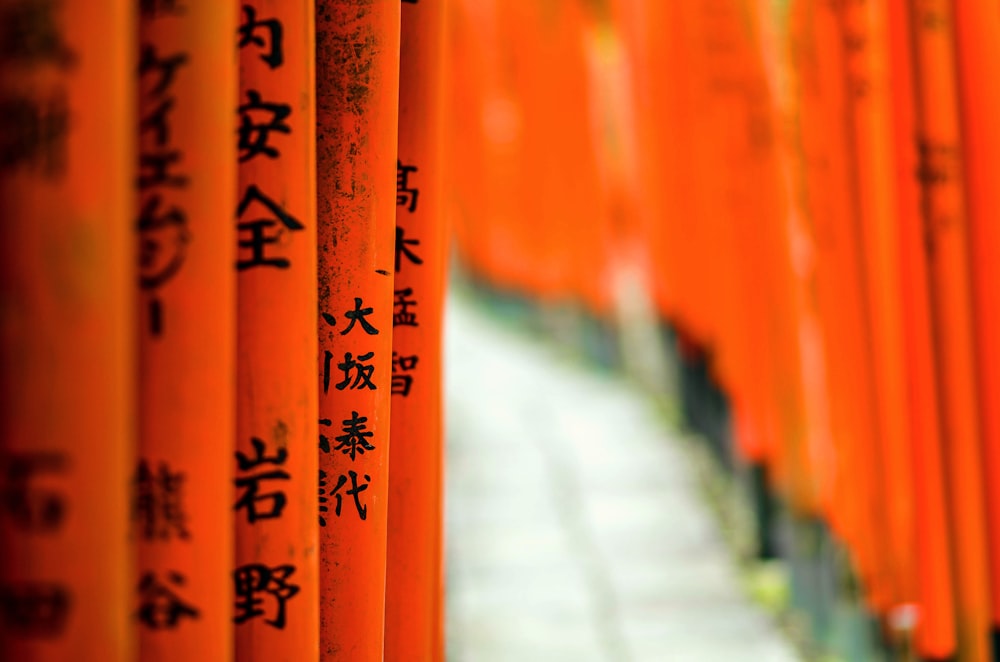 eine Reihe orangefarbener Stangen mit asiatischer Schrift darauf