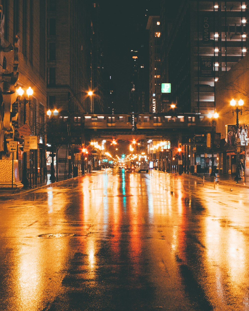 gray concrete road between buildings at night