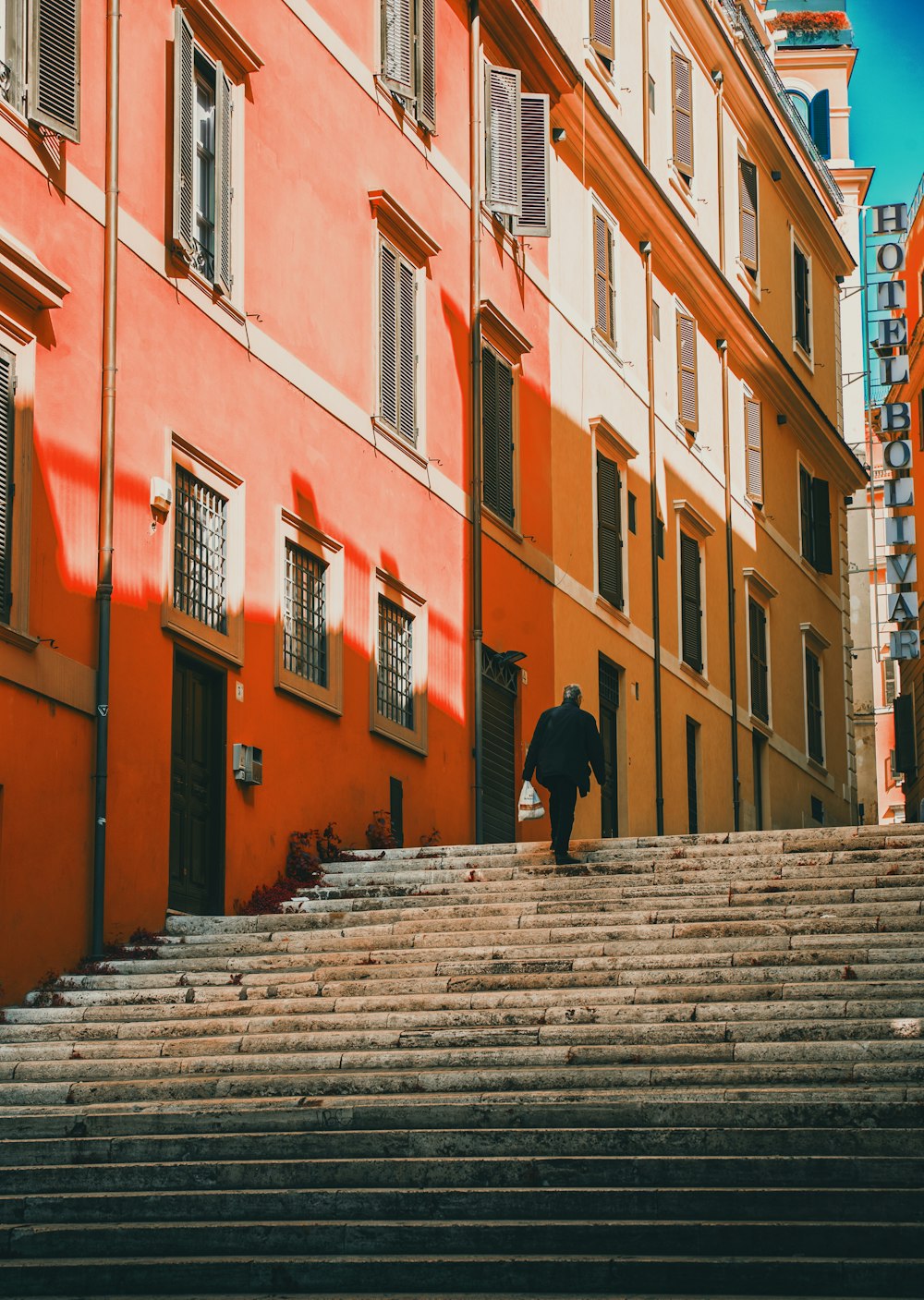 man walking on stairs beside building