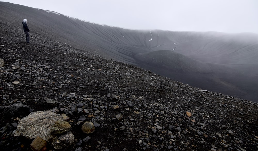 a man standing on top of a rocky hill