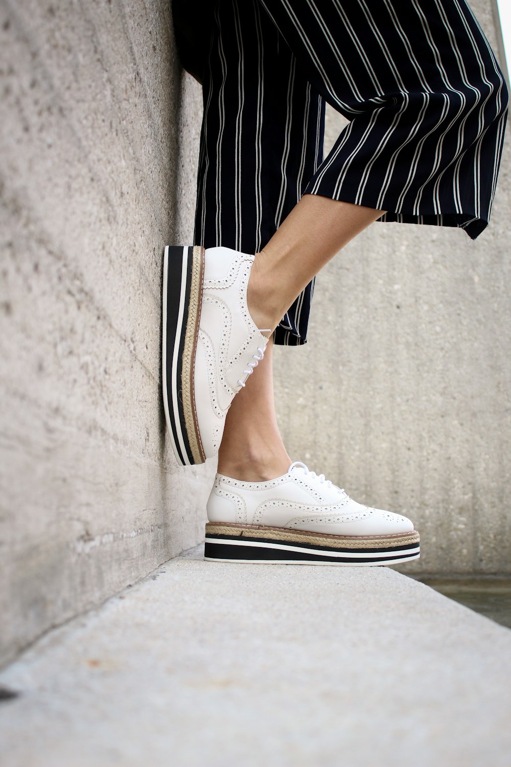 persona che indossa scarpe da ginnastica bianche