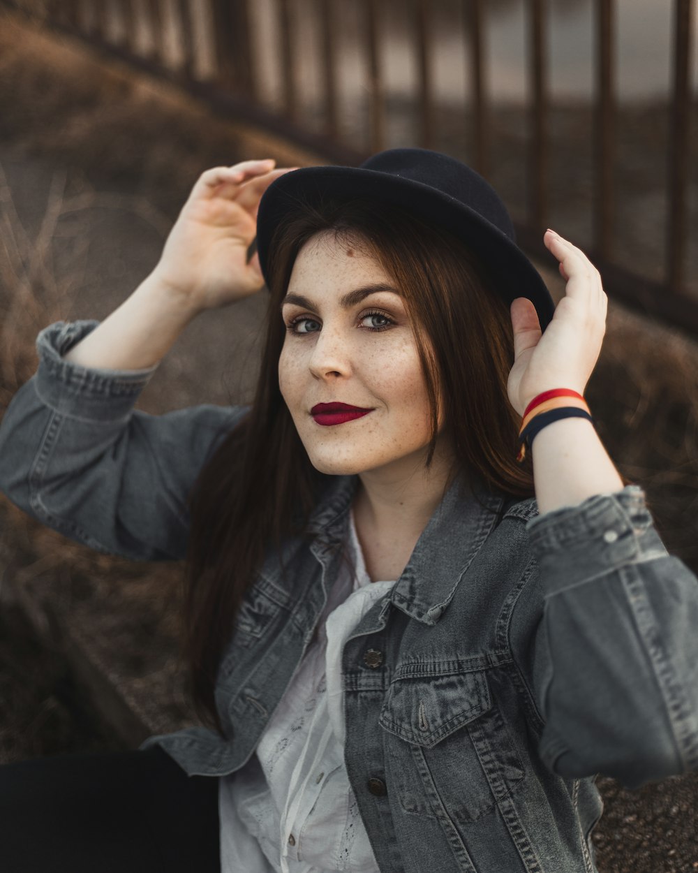 woman holding her black hat