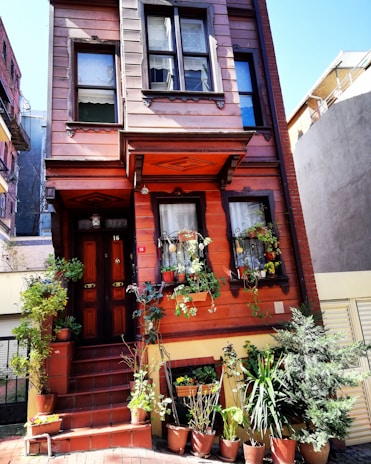 A spacious townhouse with elegant design and potted plants at the entrance.