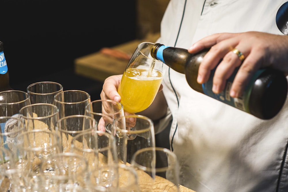 person pouring clear wine glass