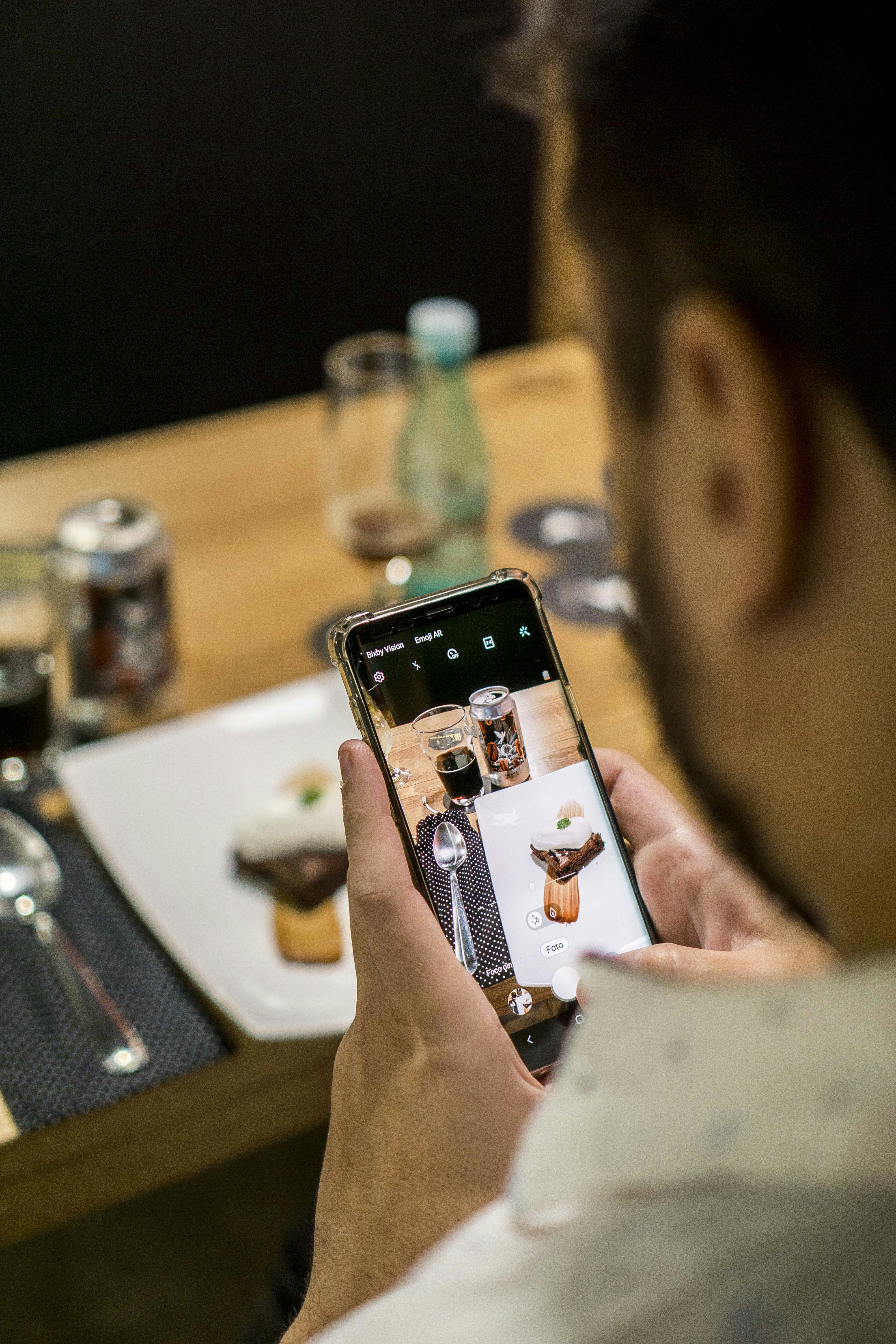 คนถ่ายภาพอาหารด้วยสมาร์ตโฟนในร้านอาหาร — Instagram marketing