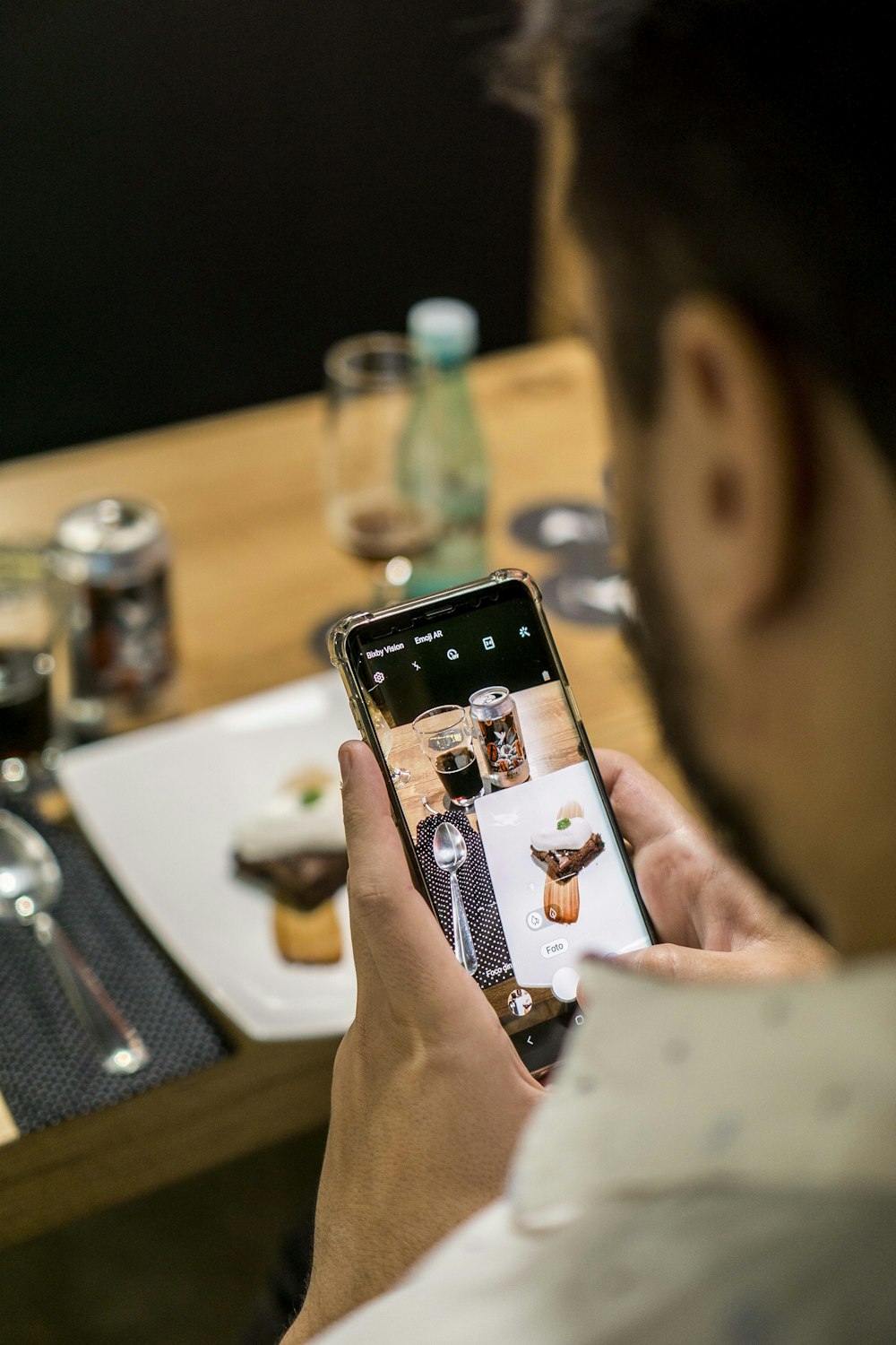 man taking photo using black Android smartphone