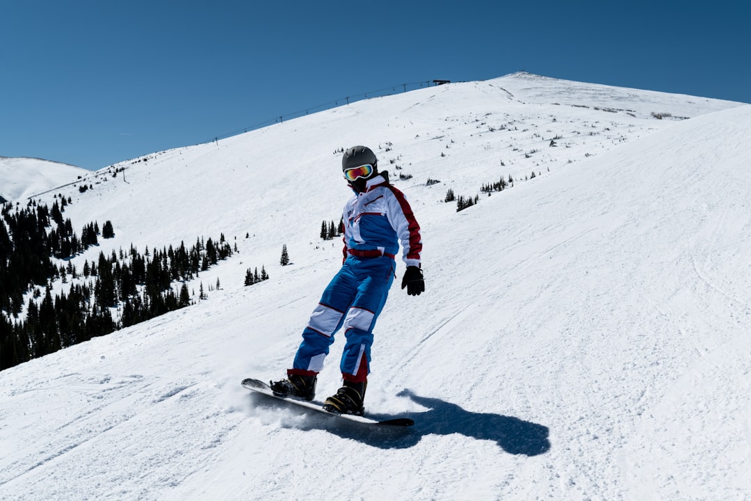 person riding snowboard on top of mountian