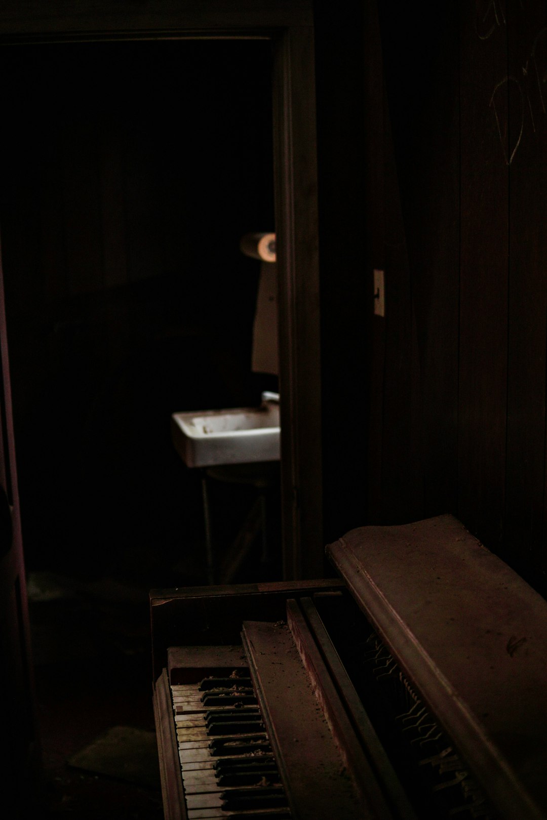 brown piano beside door