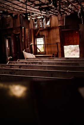 Atmospheric photo of an abandoned building interior with natural light streaming through broken windows.