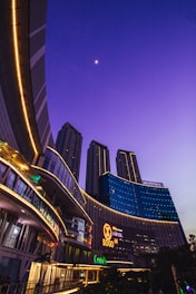 A sleek commercial district with 3D rendered office buildings and shopping malls under a twilight sky.