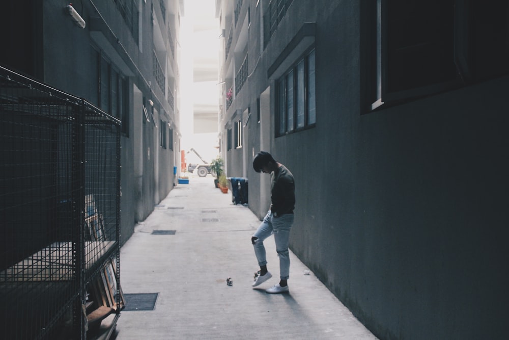 man standing between buildings