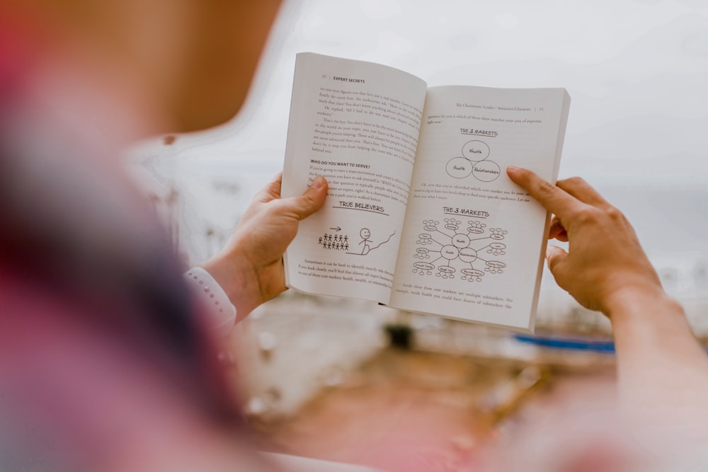 personne lisant un livre pendant la journée