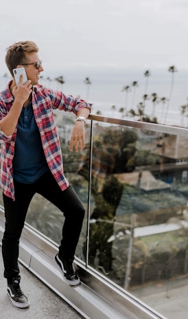 unknown person in red plaid shirt talking on phone at terrace