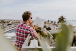 man reading book on balcony during daytim