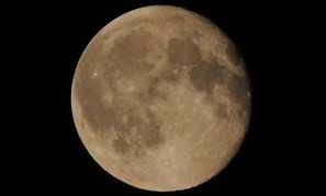 A close view of the detailed surface texture of a 3D printed moon lamp under soft lighting