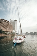 white sailboat at the river during daytime