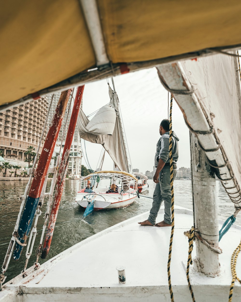 man standing on sailboat near building