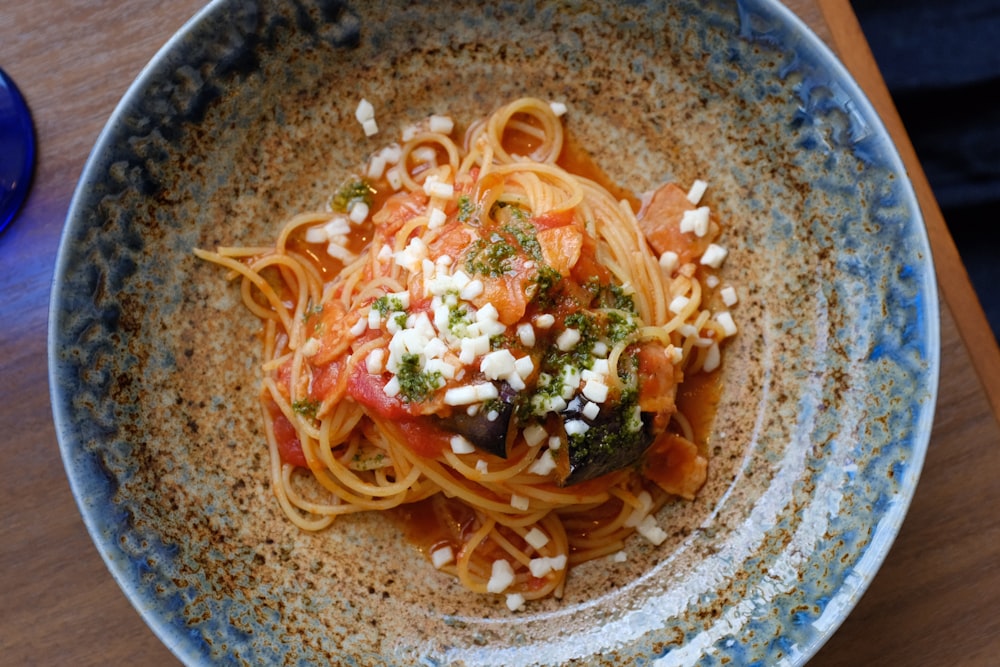 noodles in brown and blue ceramic bowl