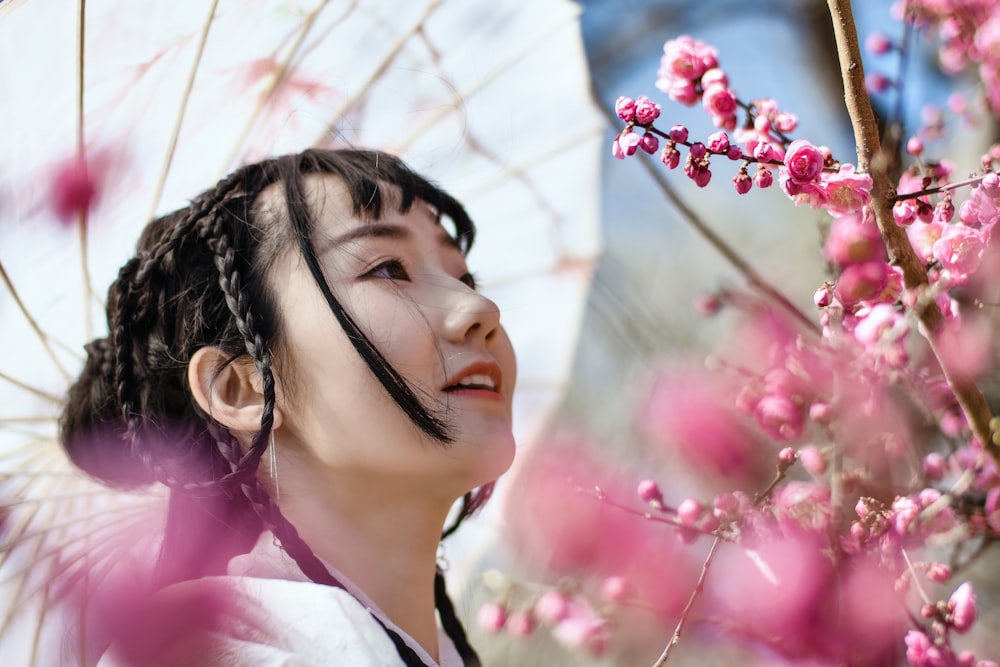 Selektive Fokusfotografie einer Frau, die in der Nähe von Blumen steht