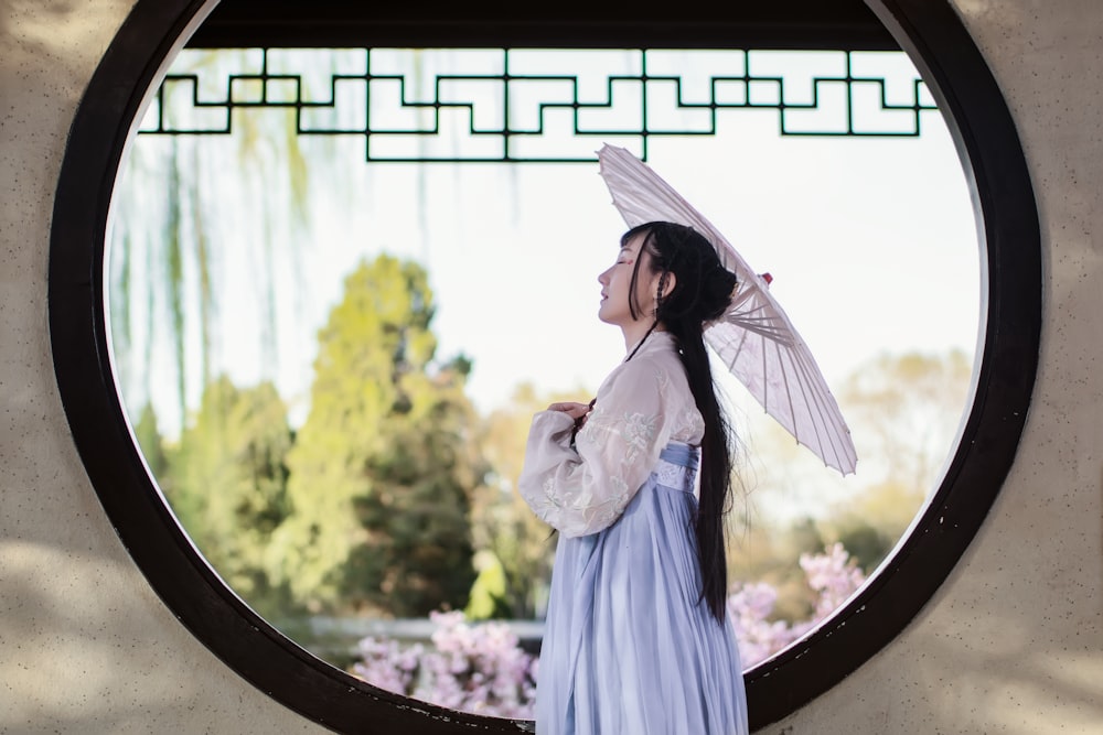 woman in white and blue dress holding umbrella