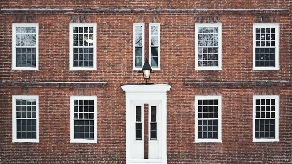 Edificio de hormigón marrón con ventanas enmarcadas en blanco